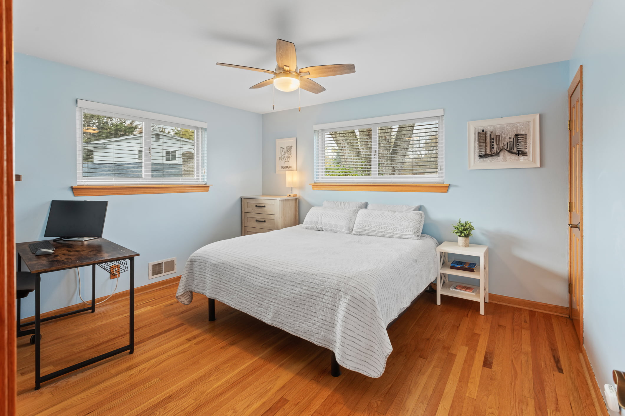Interior bedroom view for Belmont Neighborhood Listing in Farmington Hills. It’s a full bed with blue walls with wood floors