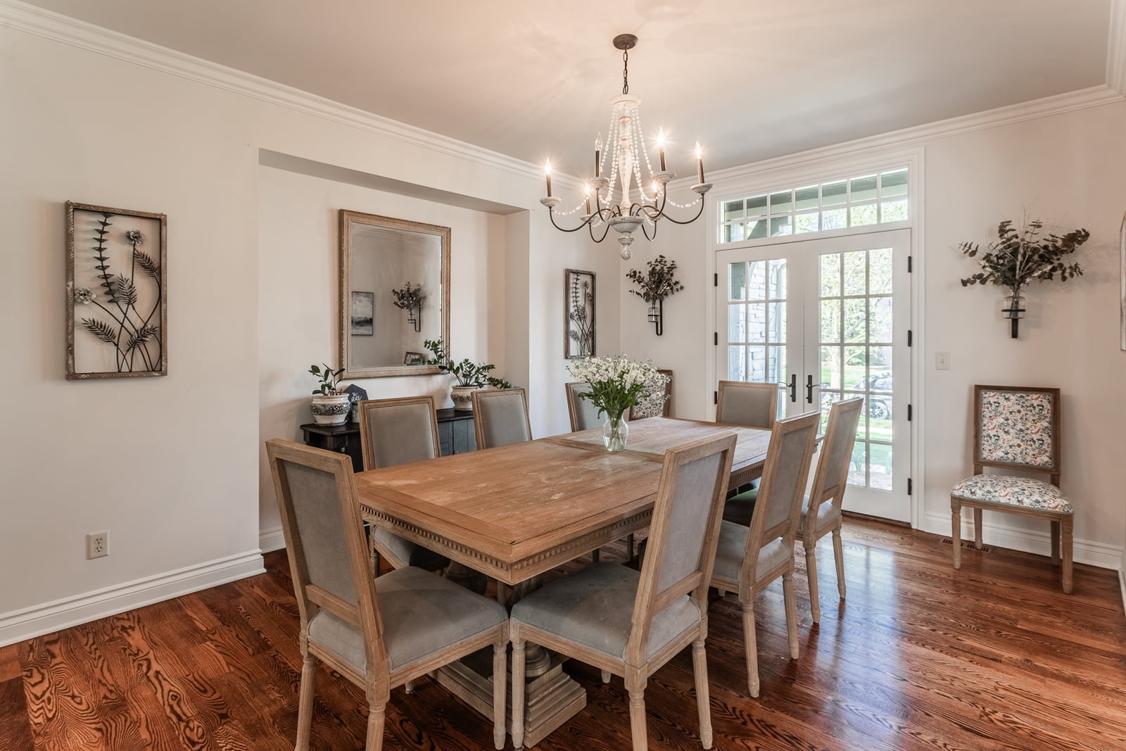 Formal dining space in a Farmington home featuring wood flooring, a decorative chandelier, and French doors to the exterior.