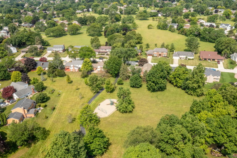 Aerial view of 25410 Liberty in Farmington Hills showing surrounding homes, mature trees, open green space, and a neighborhood playground.